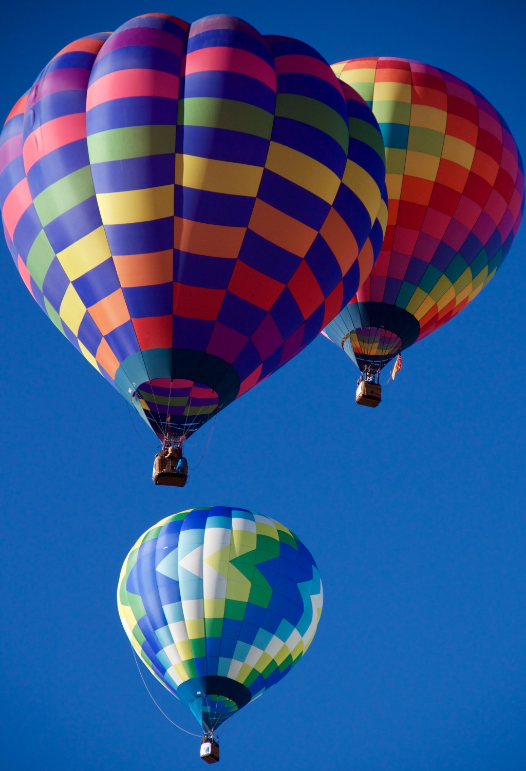 three hot air balloons lifting off